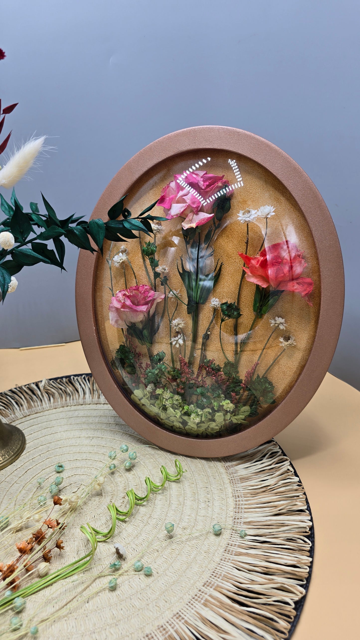 Tablou floral oval cu trandafiri criogenați și flori naturale conservate – ramă roz pudrat 30x25